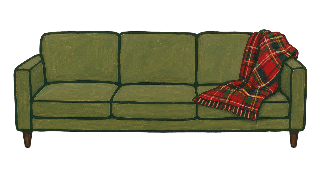a green couch with a red plaid blanket over one arm